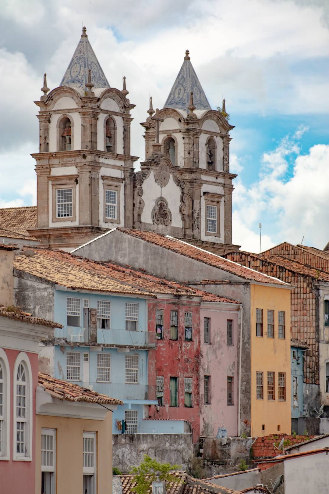 Picture of a church facade with colorful buildings in the foreground.
